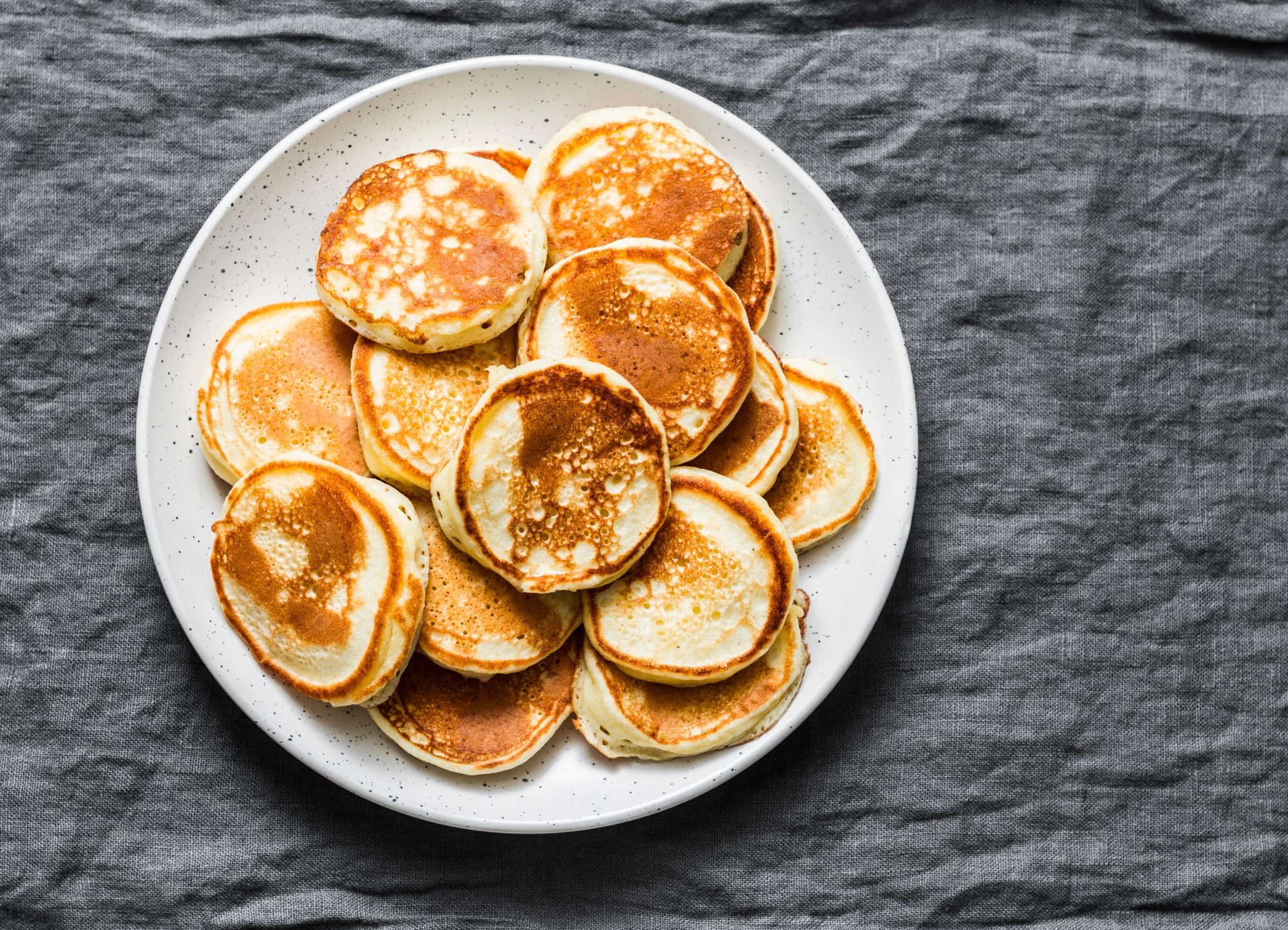 Plate full of small pancakes, top view